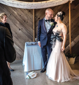 A groom in a tuxedo and a bride in a long gown look into each other's eyes.